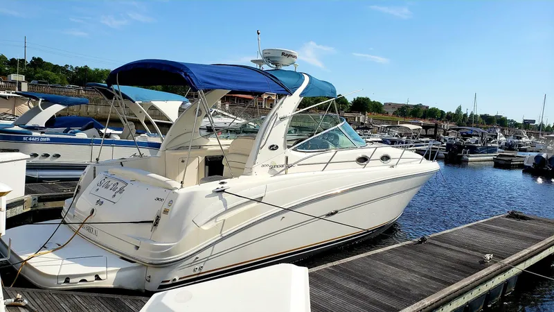 Slide: The Image of 2002 Sea Ray 300 Sundancer docked at marina with blue canopy. - 2