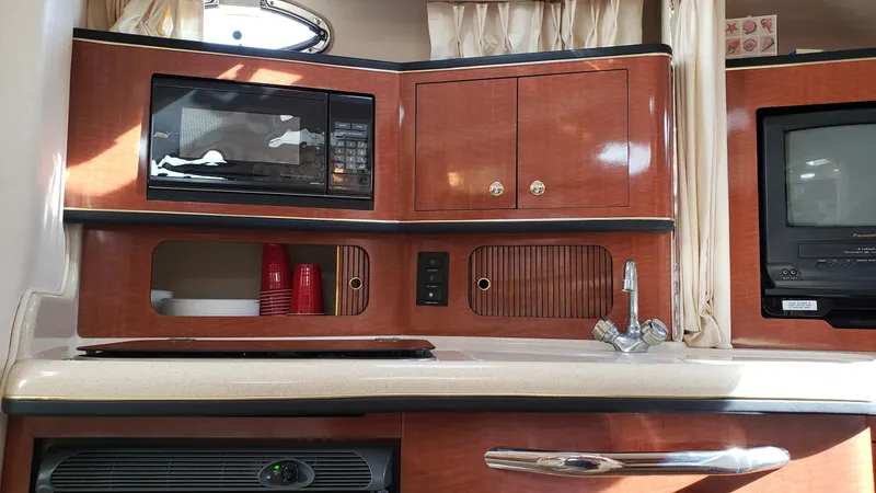 Slide: The Image of 2002 Sea Ray 300 Sundancer interior with microwave, sink, and storage cabinets. - 20