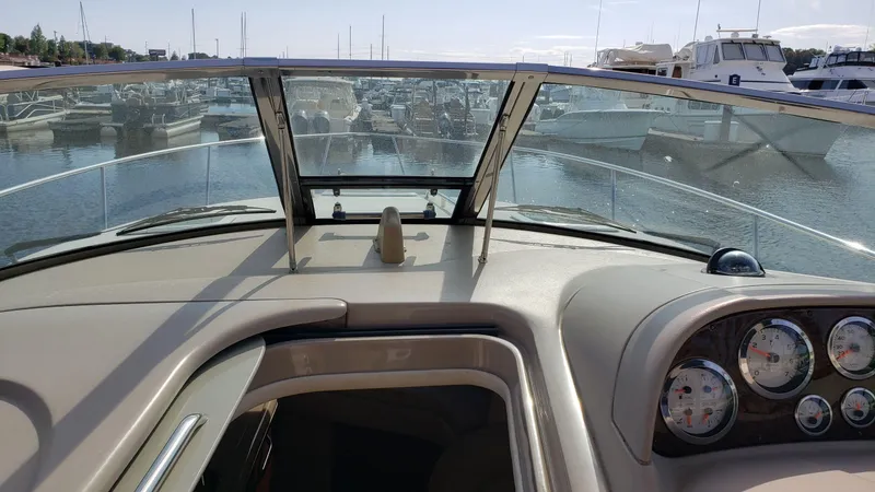 Slide: The Image of 2002 Sea Ray 300 Sundancer dashboard view at marina, showcasing gauges and windshield. - 30