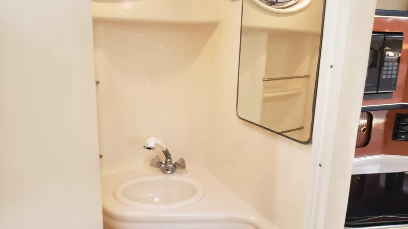 Slide: The Image of 2002 Sea Ray 300 Sundancer bathroom with sink, mirror, and compact design. - 32