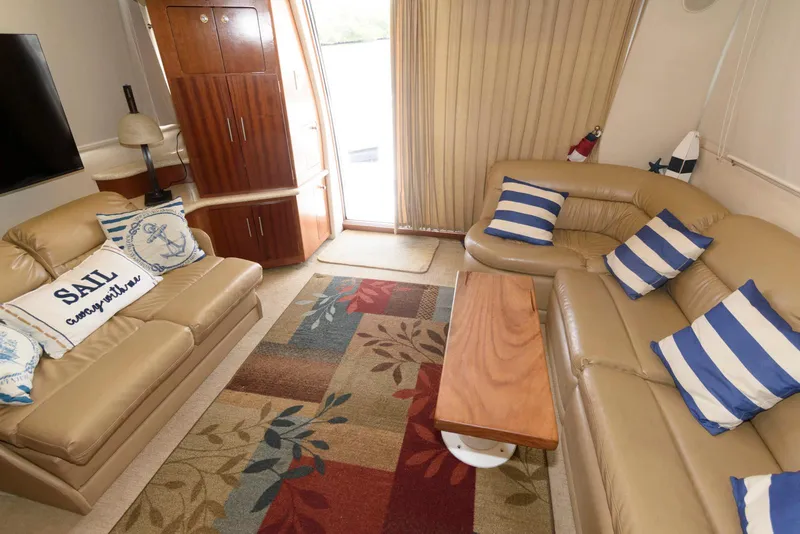Slide: The Image of Luxurious interior of 1999 Carver 450 Voyager Pilothouse with beige sofas and nautical decor. - 14