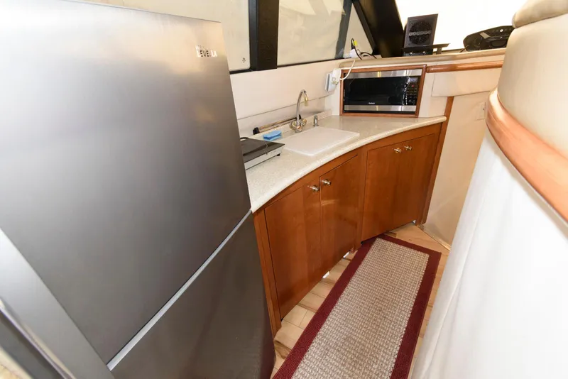 Slide: The Image of 1999 Carver 450 Voyager Pilothouse kitchen with fridge, sink, and microwave. - 15