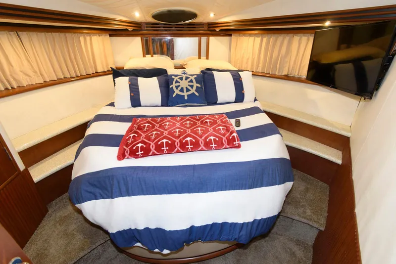 Slide: The Image of 1999 Carver 450 Voyager Pilothouse bedroom with nautical-themed bedding and modern decor. - 17