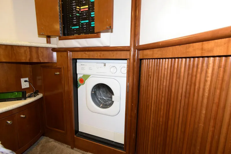 Slide: The Image of Laundry area in 1999 Carver 450 Voyager Pilothouse with washer and wooden cabinetry. - 18