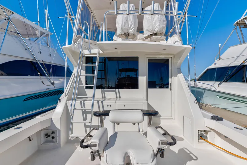 Slide: The Image of 1999 Viking 47 Convertible yacht with fishing chair and ladder, docked at marina. - 12