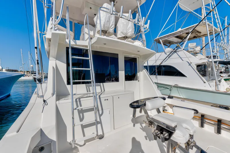 Slide: The Image of 1999 Viking 47 Convertible yacht with fishing chair and ladder, docked in a marina. - 13