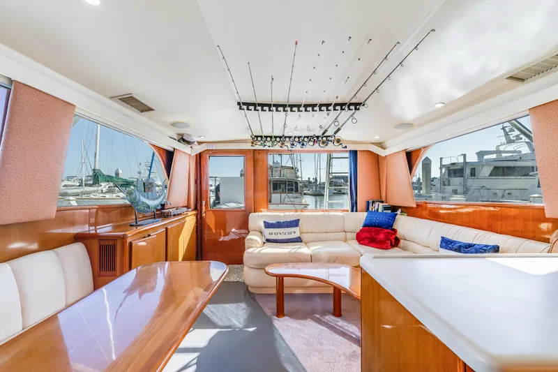 Slide: The Image of Luxurious interior of a 1999 Viking 47 Convertible yacht with plush seating and fishing rods. - 17