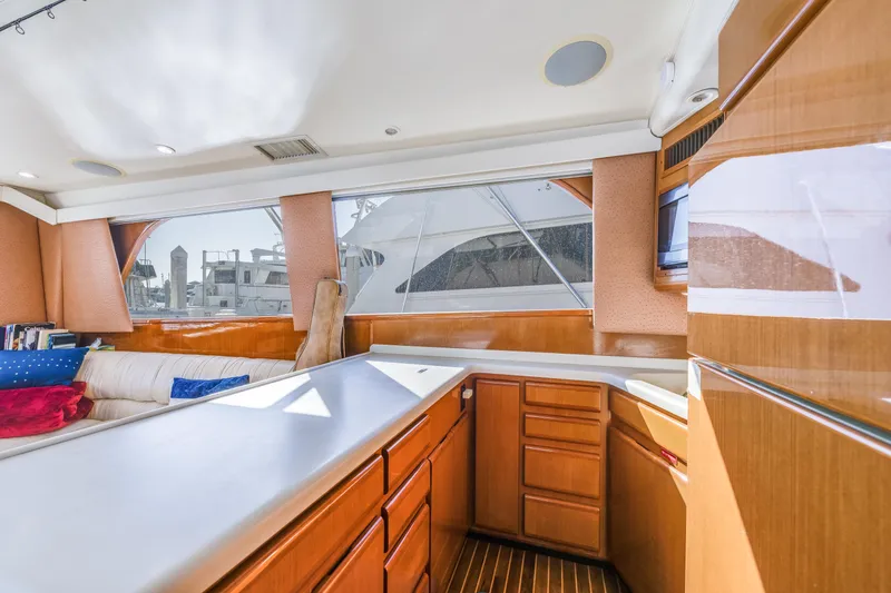 Slide: The Image of Interior of 1999 Viking 47 Convertible yacht with wooden cabinetry and large windows. - 22