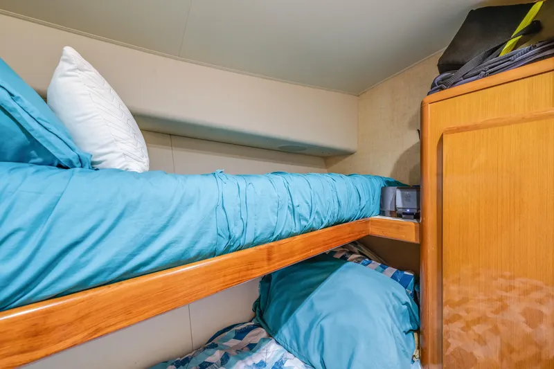 Slide: The Image of Bunk beds in a 1999 Viking 47 Convertible yacht cabin with blue bedding. - 27