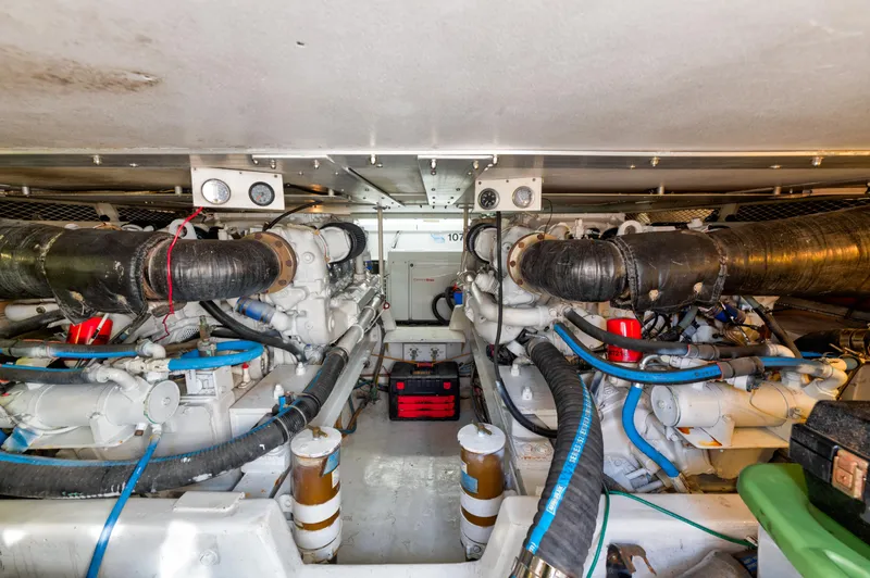 Slide: The Image of Engine room of a 1999 Viking 47 Convertible yacht, featuring dual engines and various components. - 29