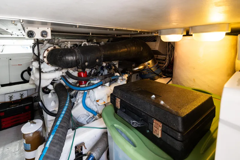 Slide: The Image of Engine room of a 1999 Viking 47 Convertible yacht, featuring mechanical components and storage. - 30