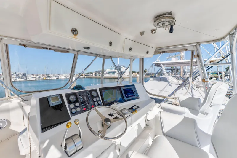 Slide: The Image of Interior helm of 1999 Viking 47 Convertible yacht with navigation equipment and marina view. - 5