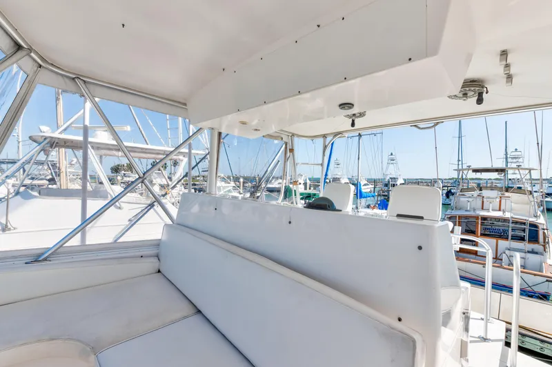 Slide: The Image of 1999 Viking 47 Convertible yacht interior with white seating and marina view. - 8