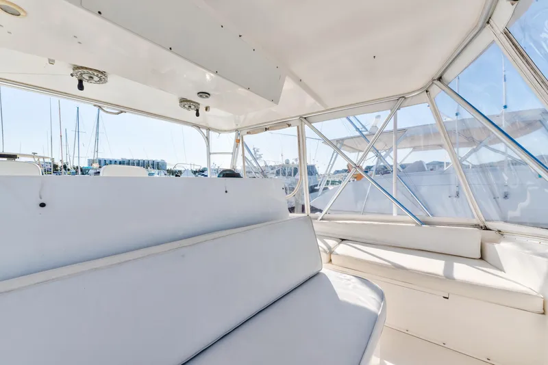 Slide: The Image of Interior view of 1999 Viking 47 Convertible yacht with white seating and windows. - 9