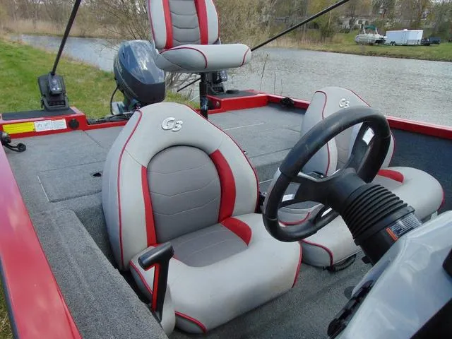 Slide: The Image of 2018 G3 Sportsman 17 boat interior with steering wheel and seating by a river. - 13