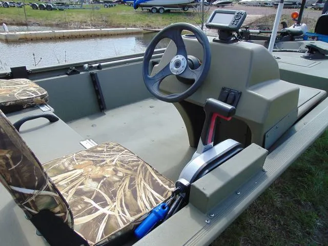 Slide: The Image of 2020 Tracker GRIZZLY® 1648 SC boat interior with steering wheel and camo seats. - 8