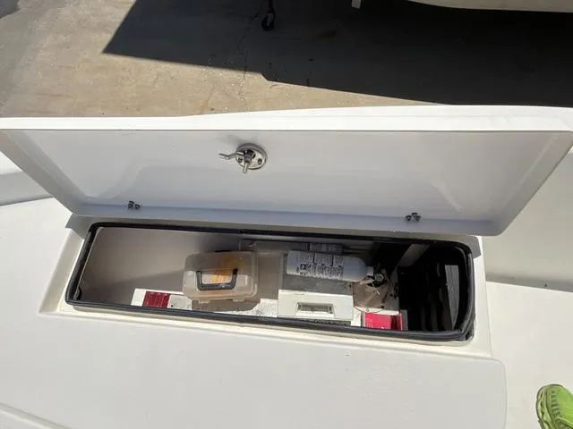 Slide: The Image of Open storage compartment on a 2007 Blazer 2220 Pro boat, containing safety equipment. - 11