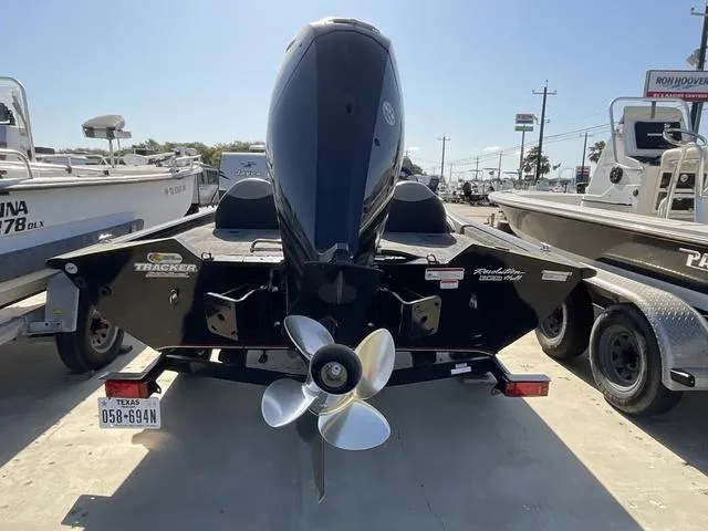 Slide: The Image of 2015 Tracker Pro 175 boat with outboard motor, parked on a trailer in a marina. - 5