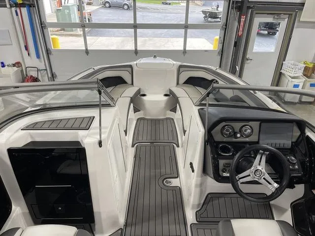 Slide: The Image of 2018 Yamaha Boats 212 Limited S interior with sleek design and modern dashboard in a garage setting. - 12