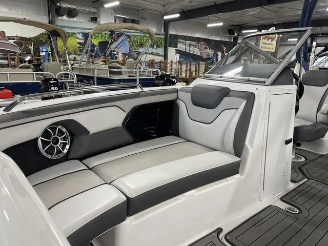 Slide: The Image of 2018 Yamaha Boats 212 Limited S interior with sleek seating and modern design in showroom. - 14