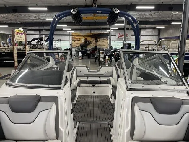 Slide: The Image of 2018 Yamaha Boats 212 Limited S interior with sleek seating and modern design in showroom. - 19