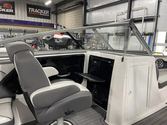 Slide: The Image of 2018 Yamaha Boats 212 Limited S interior with gray seating and dashboard in showroom. - 21
