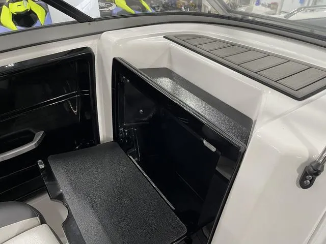 Slide: The Image of 2018 Yamaha Boats 212 Limited S interior storage compartment with sleek black and white design. - 22