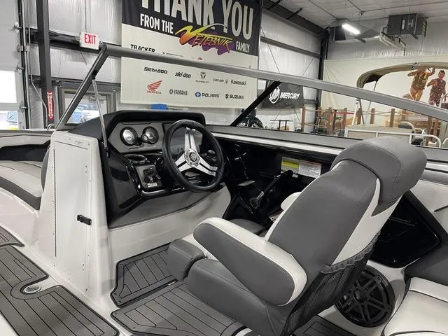 Slide: The Image of 2018 Yamaha Boats 212 Limited S interior with steering wheel and seating in showroom. - 23