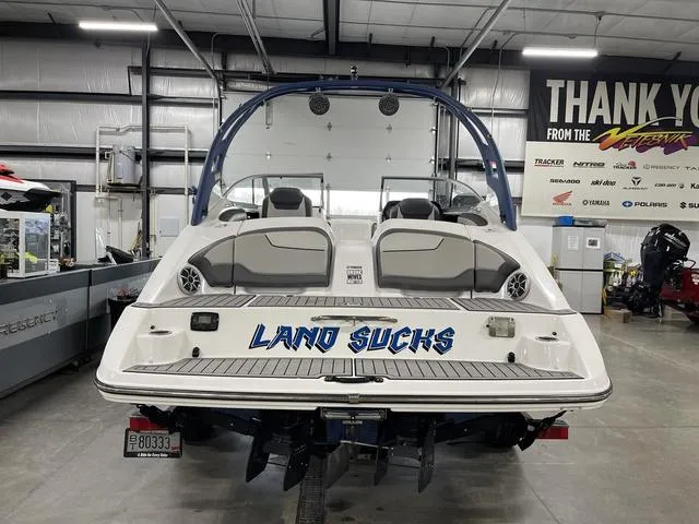 Slide: The Image of 2018 Yamaha Boats 212 Limited S in a showroom, featuring "Land Sucks" text on the back. - 4
