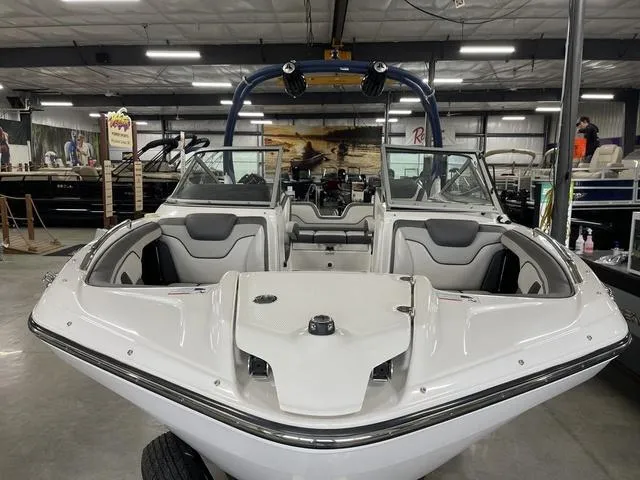 Slide: The Image of 2018 Yamaha Boats 212 Limited S in showroom, front view, sleek white design. - 8