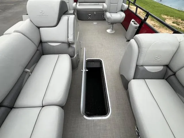 Slide: The Image of 2024 Regency 250 DL3 pontoon boat interior with gray seating and open storage compartment. - 17
