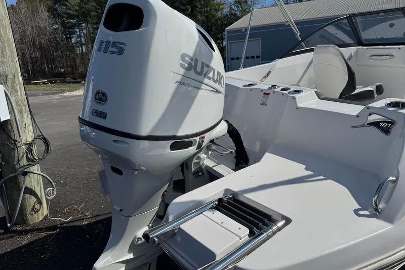 Slide: The Image of 2025 Stingray 191 DC boat with Suzuki 115 outboard motor, parked outdoors. - 7