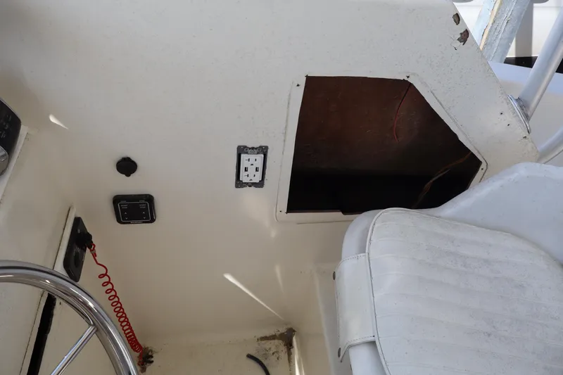 Slide: The Image of 2005 Sea Boss 235 Walkaround interior with steering wheel and storage compartment. - 11
