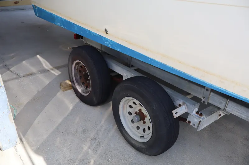 Slide: The Image of Trailer wheels of a 2005 Sea Boss 235 Walkaround boat on concrete surface. - 3