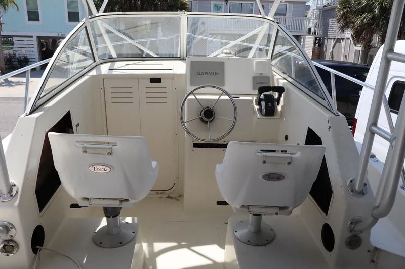Slide: The Image of 2005 Sea Boss 235 Walkaround boat interior with dual seats and steering wheel. - 8