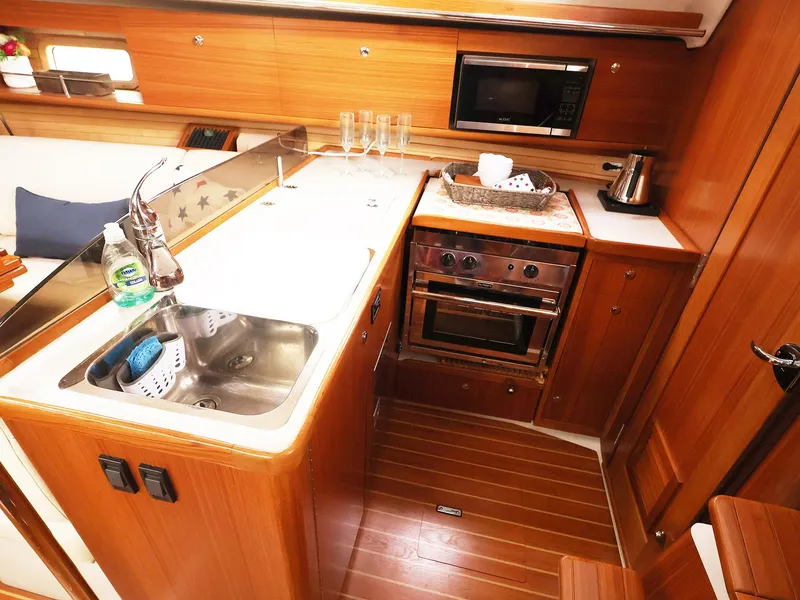 Slide: The Image of 2021 Catalina C355 yacht kitchen with wooden cabinetry, stainless steel sink, and modern appliances. - 26