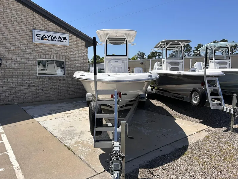 Slide: The Image of 2025 Caymas 26 HB boat displayed outside dealership, sunny day, two boats visible. - 2