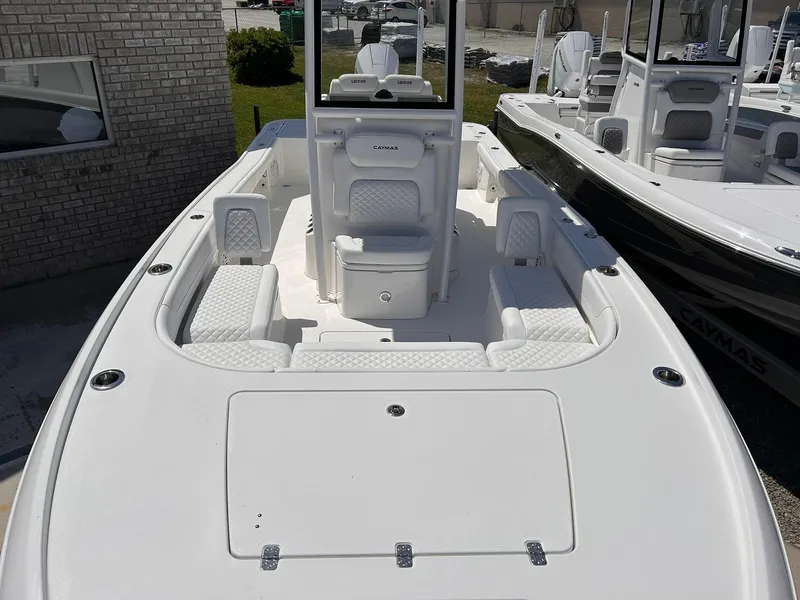 Slide: The Image of 2025 Caymas 26 HB boat with white seating and sleek design, docked outdoors. - 3