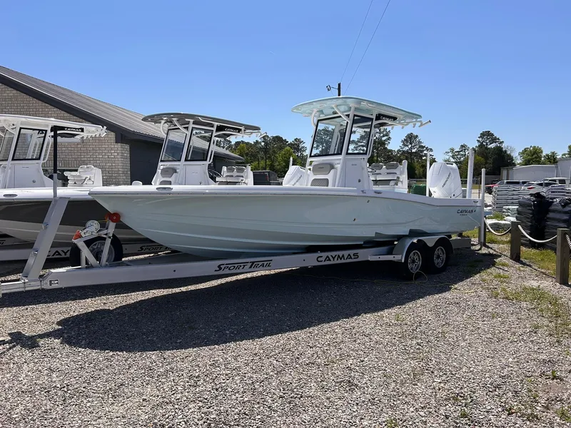 Slide: The Image of 2025 Caymas 28 HB boat on trailer, parked outdoors under clear sky. - 2