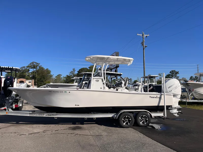 The Image of 2021 Tidewater 2500 Carolina Bay boat on trailer, parked outdoors under clear blue sky. - 0