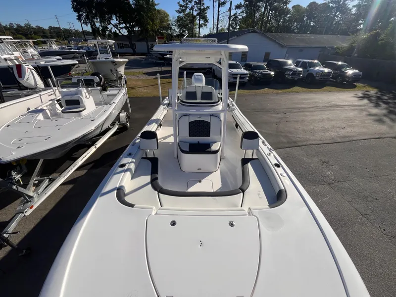 Slide: The Image of 2021 Tidewater 2500 Carolina Bay boat, white exterior, docked in a marina under clear skies. - 11