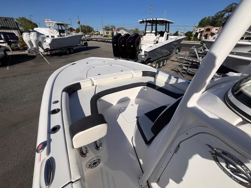 Slide: The Image of 2021 Tidewater 2500 Carolina Bay boat, white interior, docked with other boats in the background. - 12