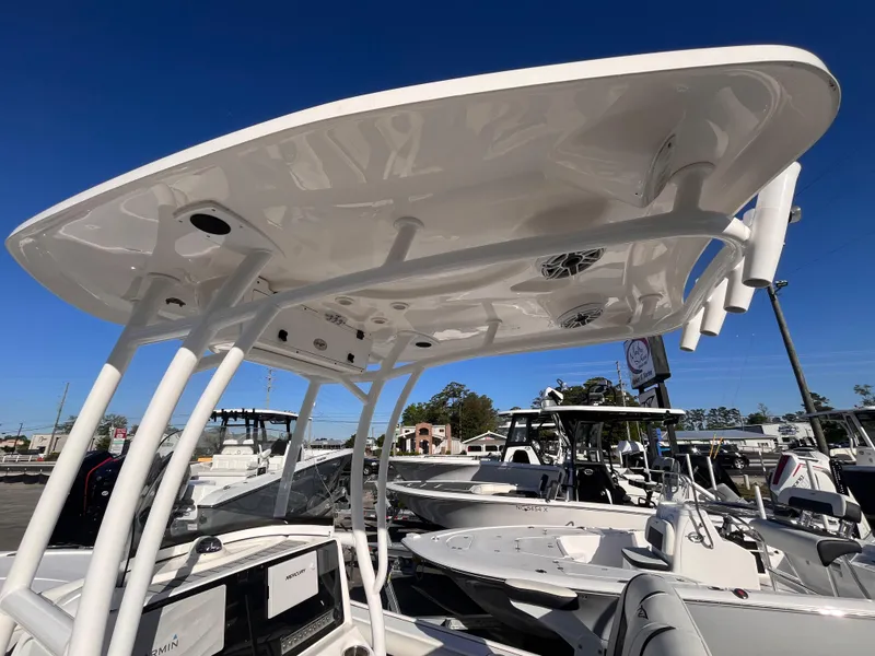 Slide: The Image of 2021 Tidewater 2500 Carolina Bay boat with T-top and rod holders, displayed outdoors. - 14