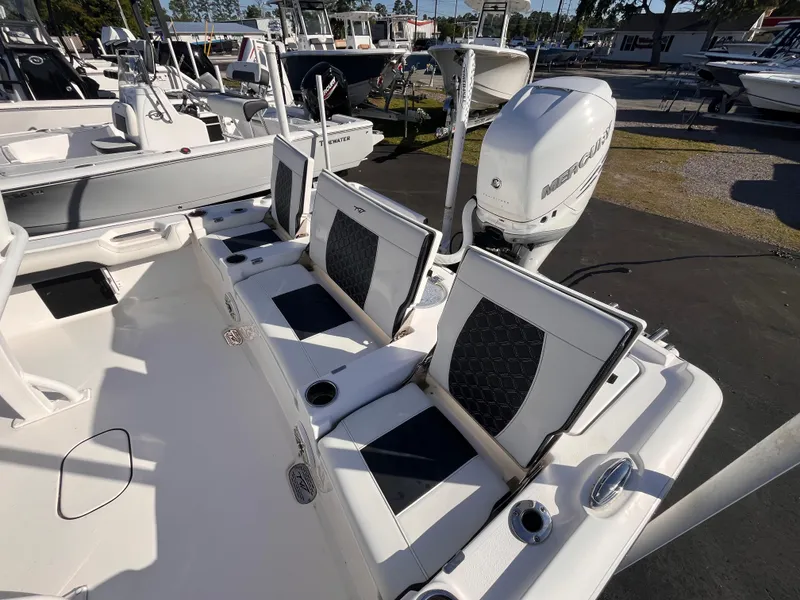 Slide: The Image of 2021 Tidewater 2500 Carolina Bay boat with seating and outboard motor in a marina. - 15