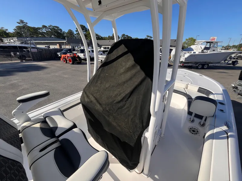 Slide: The Image of 2021 Tidewater 2500 Carolina Bay boat interior with seating and covered console in a marina. - 16