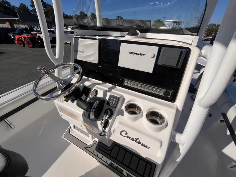 Slide: The Image of 2021 Tidewater 2500 Carolina Bay boat console with steering wheel and controls. - 8
