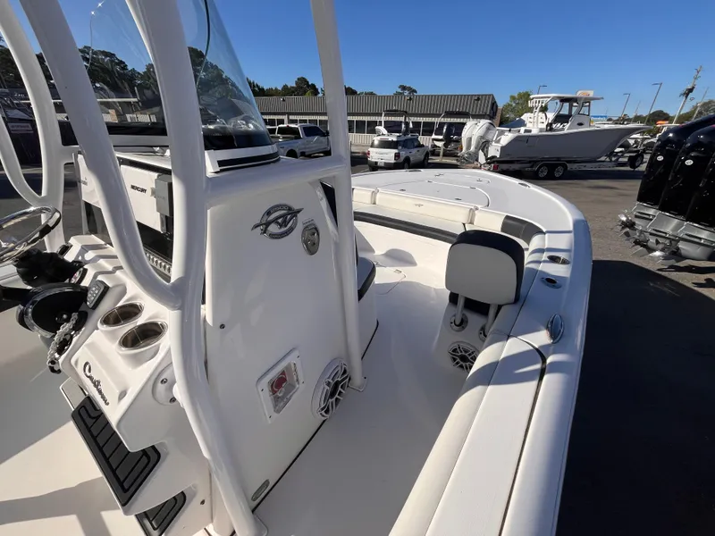 Slide: The Image of 2021 Tidewater 2500 Carolina Bay boat interior with seating and console, parked outdoors. - 9