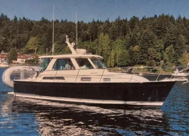 Slide: The Image of 2007 Sabre 34 Hardtop Express boat on a serene lake with forested background. - 0