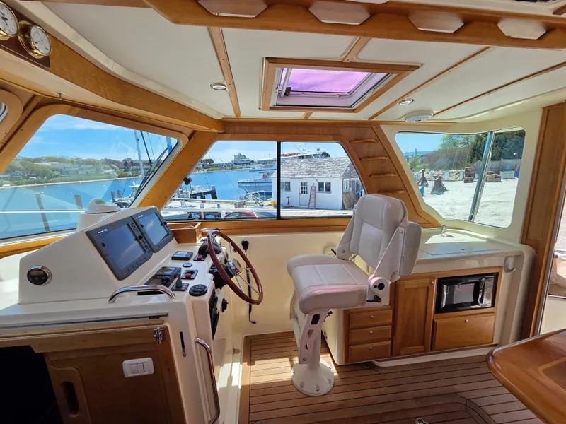 Slide: The Image of 2007 Sabre 34 Hardtop Express helm with wooden accents and marina view. - 4