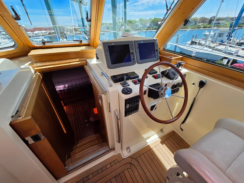 Slide: The Image of 2007 Sabre 34 Hardtop Express helm with wooden steering wheel and navigation screens. - 5